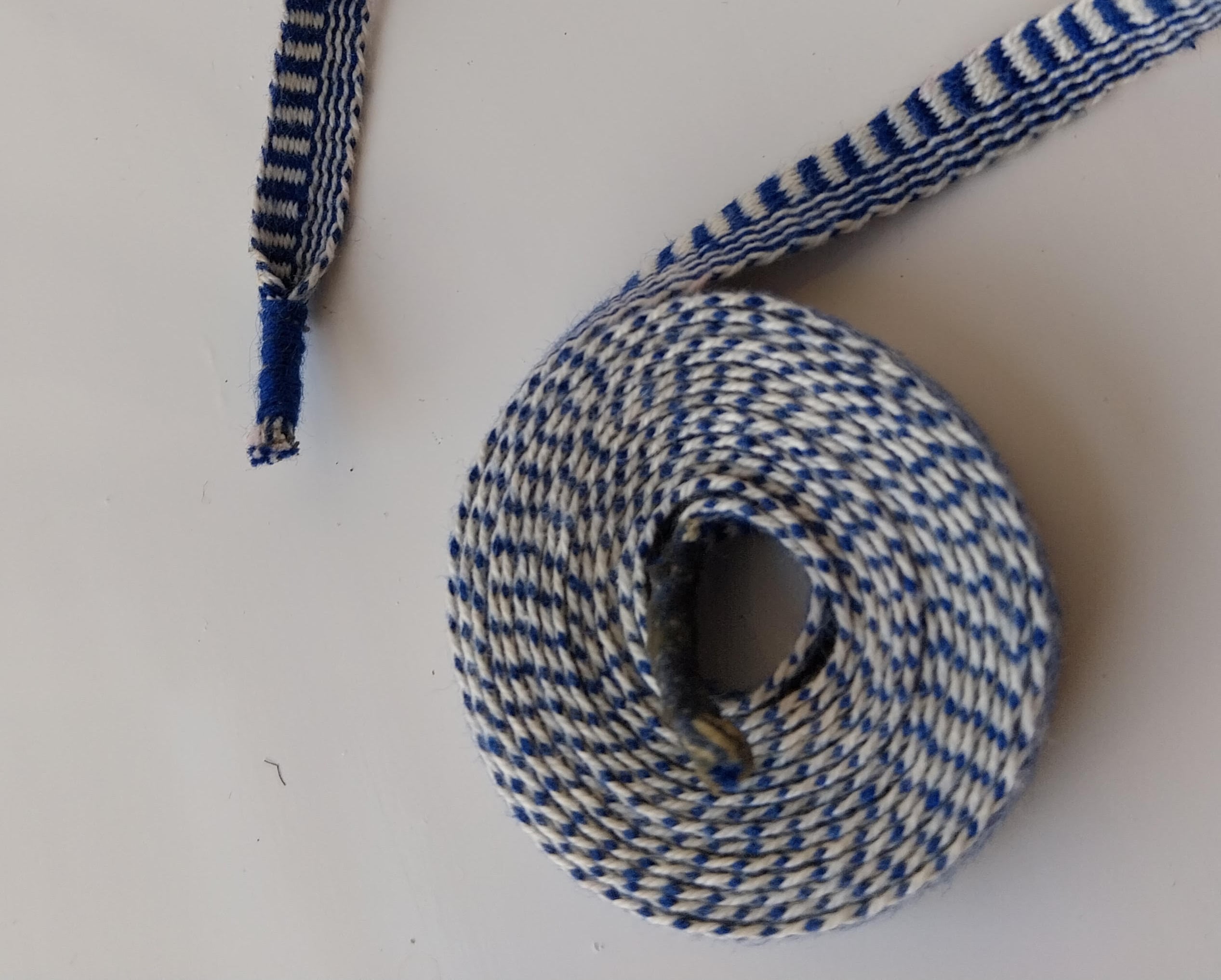 Bånd der er længdestribet på den ene halvdel og tværstribet på den anden halvdel.
Bomuld 16/2.